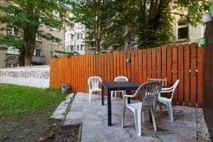 una mesa negra y cuatro sillas blancas y una valla en Modernes Apartment 1 und 2 in Dortmund Mitte, en Dortmund