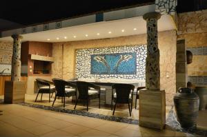 una sala da pranzo con tavolo, sedie e parete a mosaico di Casa DimiGre house in Kattavia - Prasonisi Rhodes a Kattavía