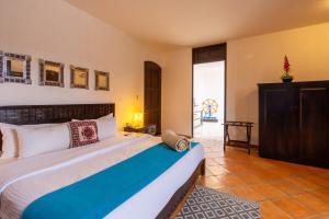 A bed or beds in a room at Hotel Hacienda San Cristóbal