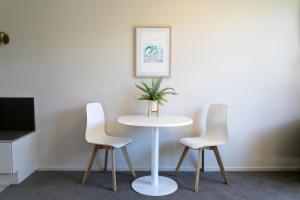 une table avec deux chaises et une table avec une plante sur elle dans l'établissement Alpine Lake Motel, à Taupo