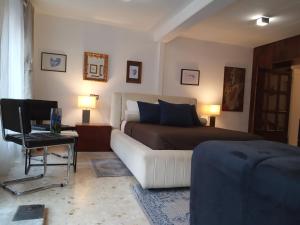 a bedroom with a bed and a white couch at Casa con Palmera - Port in Valencia