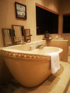 baño con bañera grande y ventana en Bristow Luxury Suites With Back Up Power and Free Wi-Fi en Roodepoort