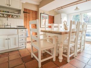 a kitchen with a table and chairs in a room at The Old Swan in Malmesbury