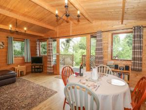 a dining room with a table and chairs at Y Caban in Llangelynin