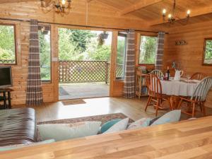 a living room with a couch and a table at Y Caban in Llangelynin