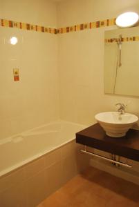 un bagno con lavandino e vasca da bagno di Lagrange Grand Bleu Vacances – Résidence La Closerie a Barjac Altre 36 foto