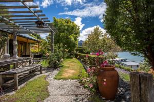 a garden with a bench and a vase of flowers at 139 On Peninsula - The ideal retreat 2 Bedroom Apartment in Queenstown