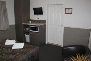 
a small room with a bed and a microwave at City Motor Inn in Toowoomba

