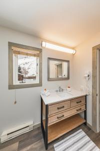 ein Bad mit einem Waschbecken und einem Spiegel in der Unterkunft Miller Park Lodge in Jackson