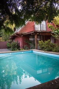 uma grande piscina azul em frente a uma casa em Hostal Helios em Los Ángeles