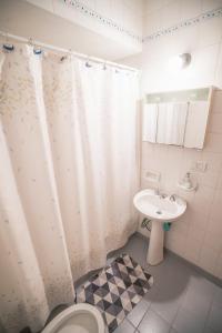 a bathroom with a white shower curtain and a sink at Departamento Ideal in Ushuaia