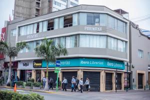 un grupo de personas caminando delante de un edificio en Pariwana Hostel Lima, en Lima