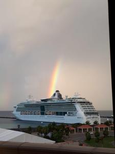 un navire de croisière avec un arc-en-ciel au-dessus de celui-ci dans l'établissement Maison Saint-Pierre2, à Philipsburg