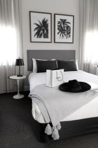 una camera da letto con un letto con un cappello sopra di St Marks Randwick a Sydney