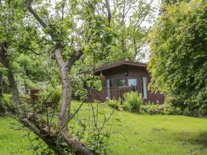 a small brick house in the middle of a yard at Y Caban in Llangelynin