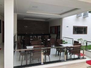 Pousada Veleiro في بورتو سيغورو: غرفة طعام بها كراسي وطاولات ولوحة