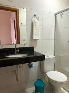 uma casa de banho com um WC, um lavatório e um espelho. em Pousada Veleiro em Porto Seguro