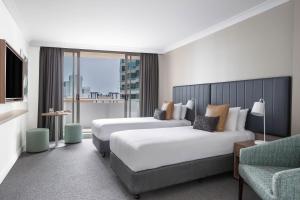 a hotel room with a large bed and a large window at Mantra Chatswood in Sydney