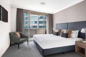 a hotel room with a large bed and a large window at Mantra Chatswood in Sydney
