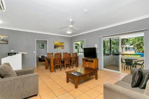 a living room filled with furniture and a tv at Cairns Reef Apartments & Motel in Cairns
