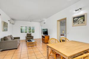 a living room filled with furniture and a table at Cairns Reef Apartments & Motel in Cairns