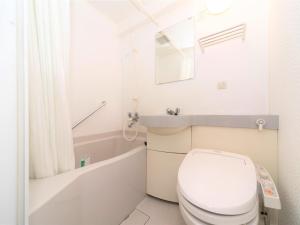 La salle de bains blanche est pourvue de toilettes et d'un lavabo. dans l'établissement APA Hotel Tennoji-Ekimae, à Osaka