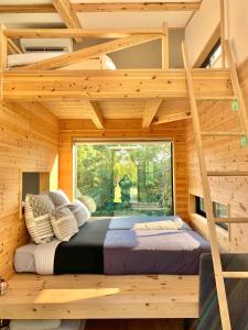 ein großes Bett in einem Holzzimmer mit Fenster in der Unterkunft Le Lodge Mimitsu in Hyuga