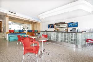 un ristorante con sedie e tavoli rossi e un bancone di Ocean Beach Hotel a Miami Beach