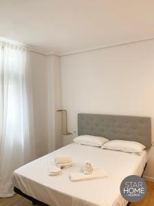 a bedroom with a bed with two towels on it at Star Home in Valencia +22 photos