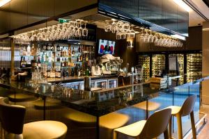 eine Bar mit einer Theke mit Stühlen und Weingläsern in der Unterkunft The Branksome Hotel & Residences in Sydney
