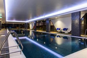 a large swimming pool in a building with blue tiles at The Branksome Hotel & Residences in Sydney