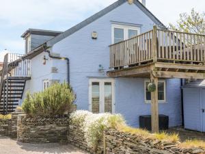 une maison bleue avec une terrasse au-dessus dans l'établissement The Blue House, à Tintagel