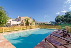 una piscina con tumbonas y sillas junto a una valla en Club Villamar - Maria Saris, en Monells