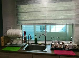 encimera de cocina con fregadero y ventana en Leisure homestay@Kota Kinabalu, en Kota Kinabalu