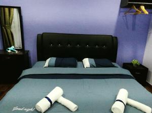 a bedroom with a large bed with a black headboard at Leisure homestay@Kota Kinabalu in Kota Kinabalu