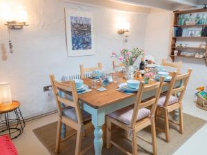 a dining room with a wooden table and chairs at Fern Cottage in Cardigan