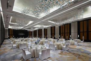 a large banquet hall with white tables and white chairs at Xianghu Xiaoyao Manor in Xiaoshan