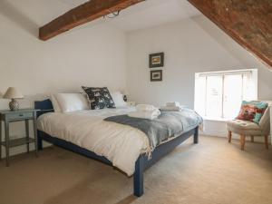 1 dormitorio con 1 cama, 1 silla y 1 ventana en The Old Swan, en Malmesbury