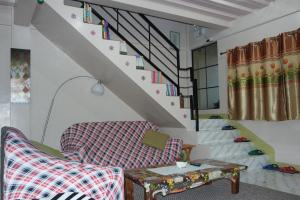 a living room with a chair and a table and stairs at YOO C Apartment - Free Netflix YouTube in Dumaguete +88 photos