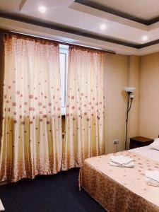um quarto com uma cama e uma janela com cortinas em Antey em Novosibirsk