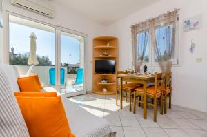 een woonkamer met een tafel en een televisie bij Apartment Sea shell in Rogoznica