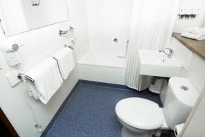 a bathroom with a white toilet and a sink at Bay Hotel Apartments in Hobart