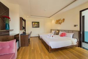 a bedroom with two beds with pink flowers on them at Hoang Trinh Hotel in Hoi An