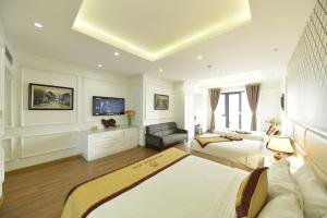 Habitación blanca grande con 2 camas y sofá en Hanoi HM Boutique Hotel, en Hanói