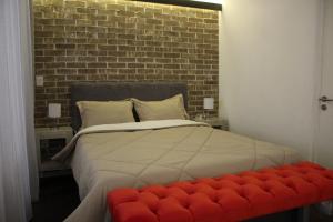 a bedroom with a large bed with a red bench at Small cozy apartment in the historic center in Puebla