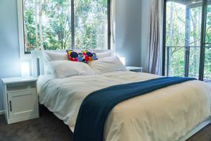 a bedroom with a bed with a large window at Treetops Haven in Maleny
