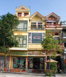 a large yellow building with tables and chairs in front of it at Ninh Binh Central Hotel in Ninh Binh