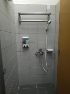 uma casa de banho com um chuveiro e uma mangueira na parede em Tsengwen Youth Activity Center em Nanxi