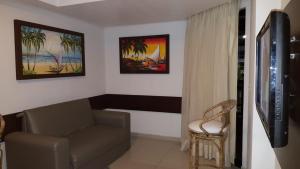 sala de estar con sofá y TV en Flat Marinas - Cabo Branco - João Pessoa, en João Pessoa