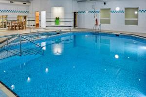 a swimming pool filled with lots of blue water at Holiday Inn Leeds Garforth, an IHG Hotel in Garforth